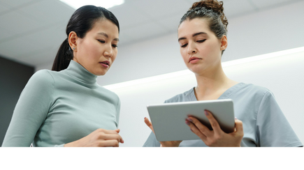 Two people are looking at a tablet